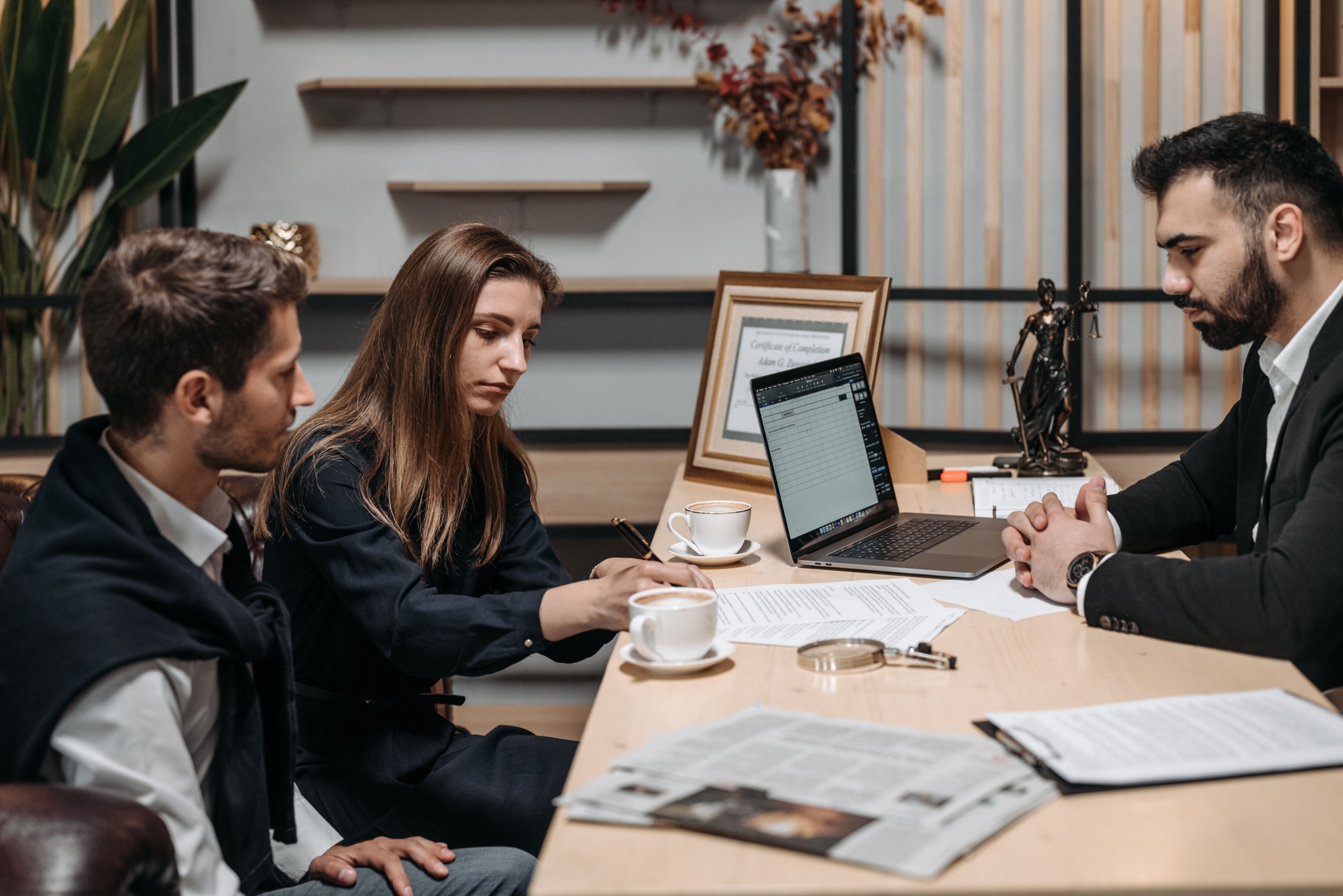 Professionals discussing documents at an office table; illustrative careers photograph